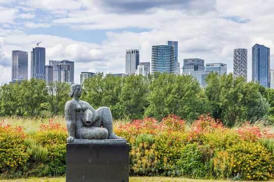 Frank Dobson Woman and Fish sculpture with Canary Wharf skyline. London, UK, 16 June 2024