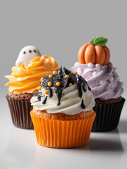 Colorful Halloween-themed cupcakes decorated with ghosts, pumpkins, and festive colors on a neutral background