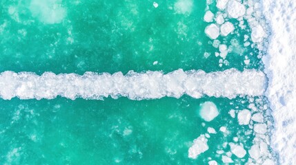 Aerial view capturing the stark contrast of icy terrain and turquoise water during winter