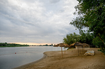 River bank with beach umbrellas and trees