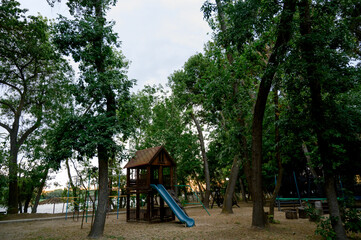 Children's playground with a view of the house and slide in the park