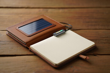 Leather bound notebook and phone case on a wooden surface