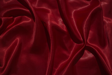 Obraz premium The luxurious red satin fabric surface is wavy and beautiful, conveying a deep love and relationship.