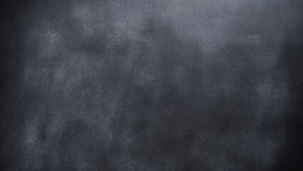 Black chalkboard texture with rubbed chalk. White chalk dust on a black chalkboard. Chalk smudges on dark blackboard. Empty classroom blackboard background with space for design.