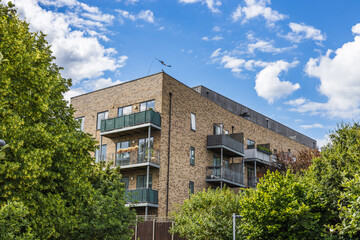 Contemporary residential brick building with balconies amid greenery