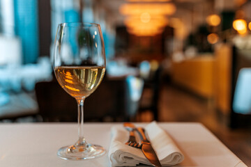 Glass of White Wine on Restaurant Table. Elegant Dining Atmosphere