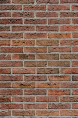 Fototapeta premium Red brick wall with varying shades and gray mortar. Texture adds character to building exterior.