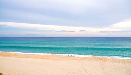 Fototapeta premium Tranquil ocean waves meeting a sandy beach.