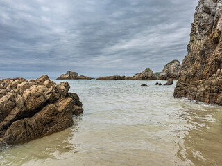 Jagged rocks and calm waters at Playa del Oso in Asturias, Spain