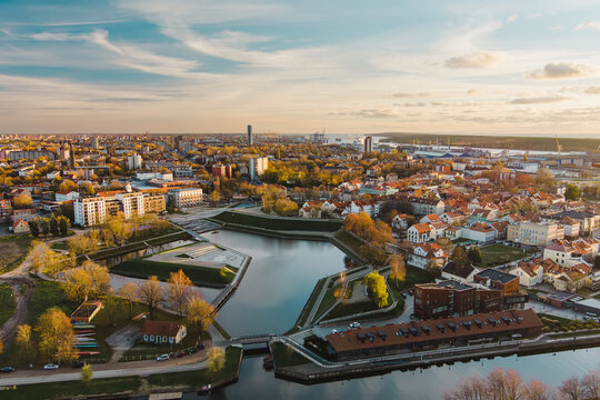 Klaipeda, a charming port city in Lithuania where old-town charm meets modern architecture, set against the backdrop of the Baltic Sea at sunset.