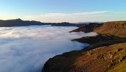 Fototapeta premium Aerial view of rugged mountains and valley shrouded in clouds