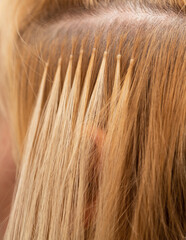 The process of blonde hair extensions. Beauty salon. Hair encapsulation. Hair extensions