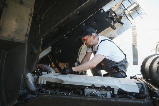 A senior worker checks wheel. Truck malfunction. Service work