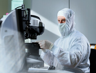 Scientist wearing protective suit working in clean room