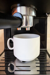 Espresso machine with white cup of coffee in the home kitchen background. Morning concept.