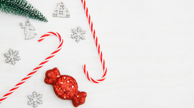 Christmas background. Christmas tree toy, candy, snowflake, fir branches on a white background.