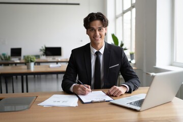 Portrait of young businessman writing notes in office professional headshot concept
