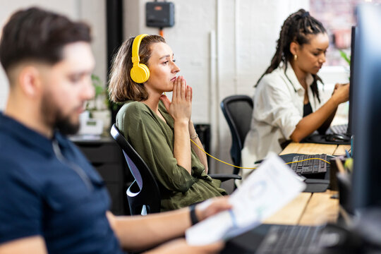 Businesswoman sitting in prayer pose at office