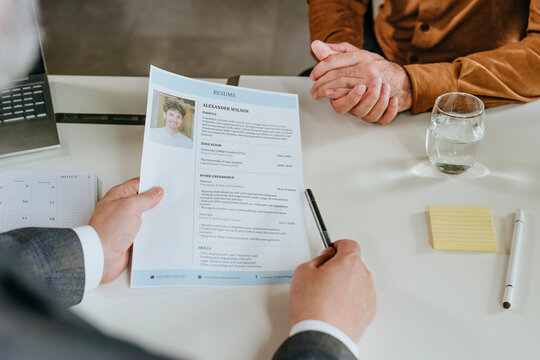 Businesspeople in office during job interview with resume on desk