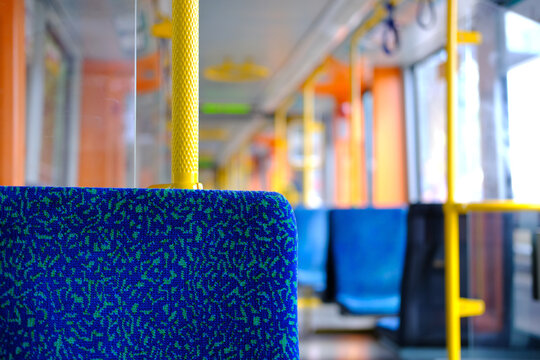 Modern public transport, offering comfortable urban travel, Spacious tram cabin with vibrant blue seats and yellow accents, Efficient urban mobility, Commuting comfort