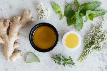 Herbal tea and fresh ingredients on light stone surface