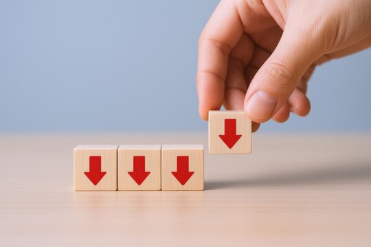 Downward Trend Concept: Hand Placing Wooden Block with Red Arrow Indicating Decrease or Decline