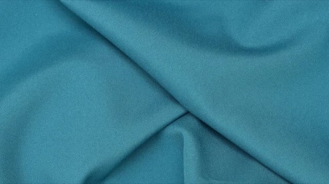 Blue polyester fabric texture with soft folds. Blue fabric background of soft and smooth textile material. Fabric texture for design and decoration. Top view.