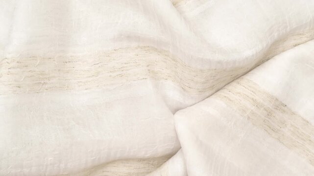 Beige and light brown polyester fabric texture with soft folds. Beige and light brown fabric background of soft and smooth textile material. Fabric texture for design and decoration. Top view.