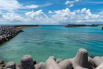 エメラルドグリーンの海に伸びる防波堤と消波ブロック