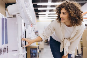 Customer choosing electric fan in appliance store