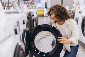 Woman Choosing Washing Machine in Appliance Store