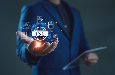 Businessman holding ISO certification icon with global network and document symbols. Concept of international standard, quality assurance, compliance, audit and corporate governance.