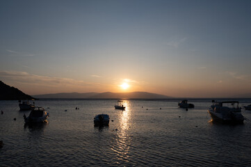 Sunset with a few boats and an island at the sea