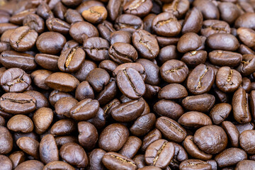 Roasted coffee beans background. Aromatic brown arabica seeds for caffeine, espresso, and morning concepts.