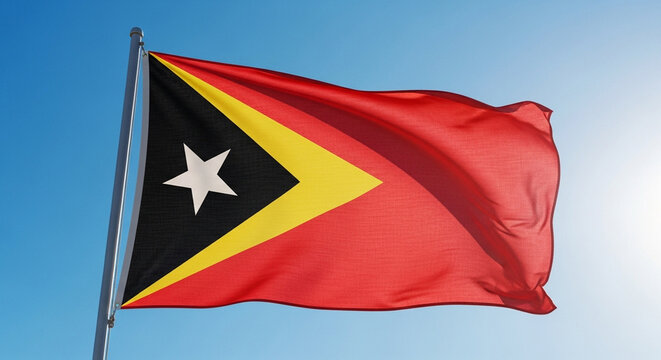 East Timor flag waving proudly against a bright blue sky, symbolizing patriotism and freedom
