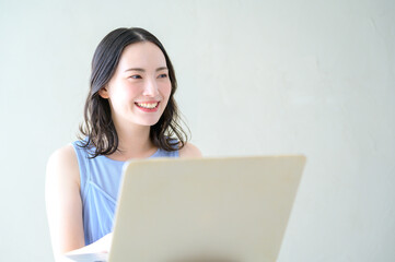 Fototapeta premium ノースリーブでパソコンを操作する日本人女性