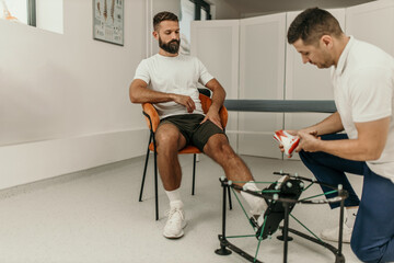 Podiatrist showing custom orthotics to patient in clinic