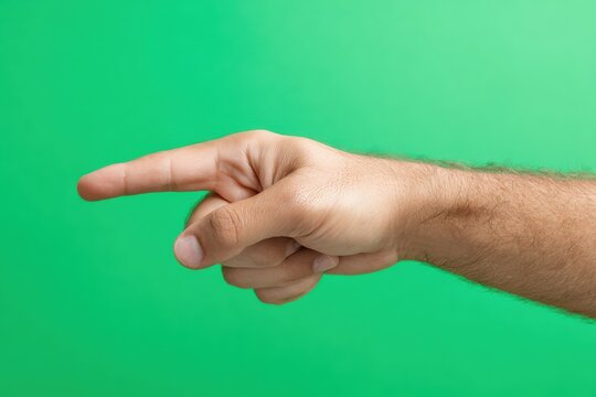 a human hand pointing sideways, close-up, sharp and clear, studio photo style, stock photo composition, green screen background