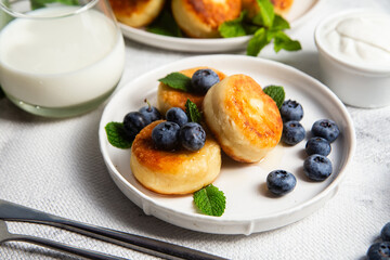 syrniki . Appetizing cheesecakes with sauce and blueberries