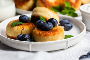 syrniki . Appetizing cheesecakes with sauce and blueberries