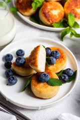 syrniki . Appetizing cheesecakes with sauce and blueberries