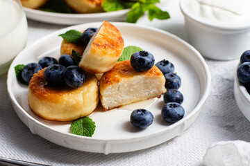 syrniki . Appetizing cheesecakes with sauce and blueberries