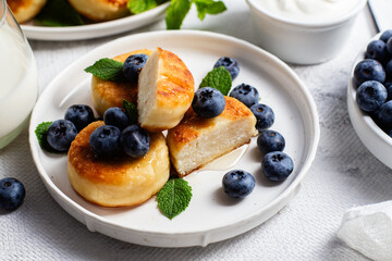 syrniki . Appetizing cheesecakes with sauce and blueberries