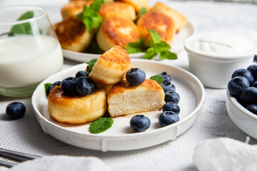 syrniki . Appetizing cheesecakes with sauce and blueberries