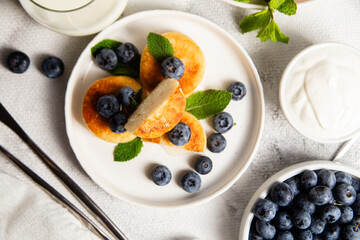 syrniki . Appetizing cheesecakes with sauce and blueberries
