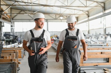 Metal processing, production of metal pipes and profiles. Two international workers at the factory.