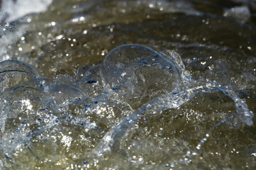 Close-up macro of water bubbles and splashes, capturing motion, texture, and transparency in an abstract aquatic detail