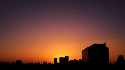 Silhouette of modern architecture against a vibrant sunset sky.
