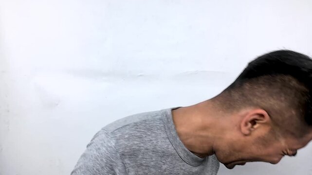 Young handsome Asian man laughing out loud hysterically.