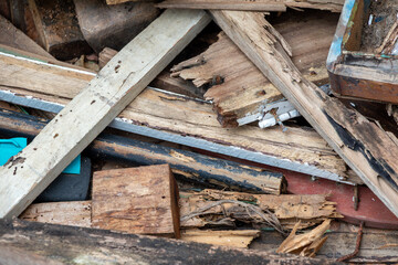 Construction waste after dismantling, a pile of wood stacked on a vacant lot for construction purposes, old wooden window and door frames.